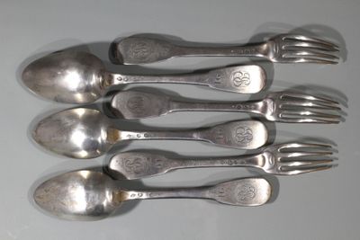 six cuillères en argent et une fourchette posées sur un plateau blanc