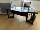 a glass desk with a laptop on top of it