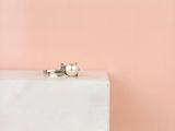 une bague de fiançailles posée sur un bloc de marbre blanc
