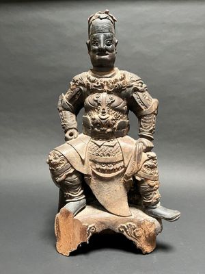 an old statue of a man sitting on a rock with a dog