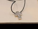 a necklace with a cross on it sitting on a table