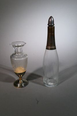 un petit vase en verre à côté d'une petite bouteille en verre