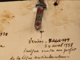 a piece of paper with writing on it that has a knife stuck in it