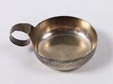 a small metal bowl with a handle on a white surface
