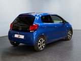 the back of a blue car is parked in a room