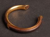 a close up of a gold bracelet on a black surface