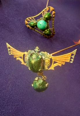 two necklaces that are sitting on a purple surface