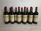 six bottles of wine are lined up on a table