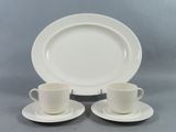deux tasses et soucoupes sont posées sur une assiette, sur une table
