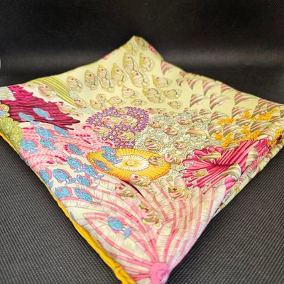 un mouchoir à motifs paisley jaunes et roses sur un fond noir