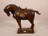 statue d'un cheval sellé, posée sur un socle, sur fond blanc