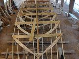un grand bateau en bois en cours de construction dans un hangar