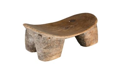 un petit banc en bois posé sur une surface blanche