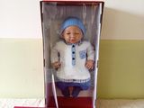 a doll in a box that is sitting on a bed