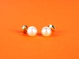 une paire de boucles d'oreilles en perles sur fond orange