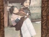 a picture of a young girl holding a baby in her arms