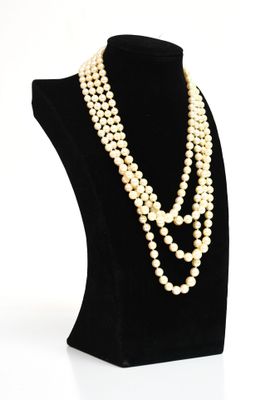 un collier de perles blanches sur un mannequin noir