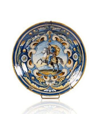 une assiette bleue et dorée sur laquelle figure l'image d'un homme à cheval