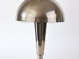 une photo d'une lampe de table argentée posée sur une surface blanche
