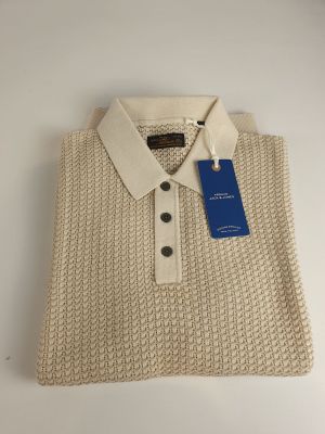 a close up of a white sweater with a blue tag on it