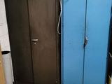 two blue cabinets in a room with a laptop on top of it