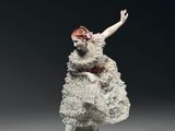 figurine en porcelaine représentant une femme vêtue d'une robe blanche et de chaussures rouges