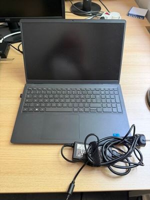 un ordinateur portable posé sur un bureau avec un chargeur
