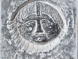 une image représentant une plaque en pierre sur laquelle figure un visage