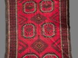 a red and black rug on a grey background