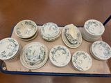 de nombreuses assiettes et bols posés sur un plateau posé par terre