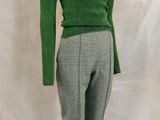 the mannequin is wearing a green sweater and gray pants