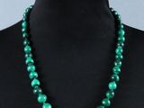 un gros plan sur un collier vert porté par un mannequin