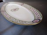 a white plate with a gold rim on a table