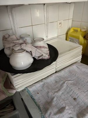 une pile d'assiettes et de tasses posée sur un plan de travail dans une cuisine