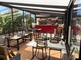 de nombreuses tables et chaises sur la terrasse d'un restaurant