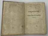 un livre ouvert, dont le titre est visible, posé sur une table