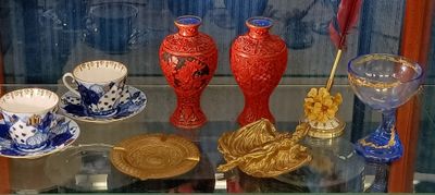 a glass display case with a variety of vases on it