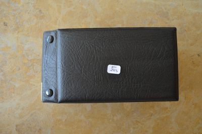 un étui en cuir noir sur lequel est collé un autocollant blanc