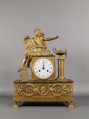 une horloge en or surmontée d'un ange