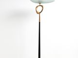 un lampadaire noir et doré surmonté d'un abat-jour en verre