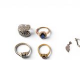 several different rings and earrings sitting on a white surface