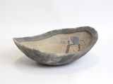 a small bowl with a bird on it on a white surface