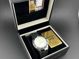 une image représentant une montre dans un coffret, à côté d'une horloge