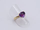 a close up of a ring with a purple stone inside of it