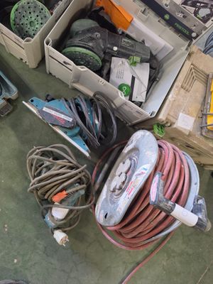 Des caisses d'outils et des outils sont posés par terre dans un garage