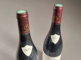 two bottles of wine sitting on top of a table next to each other