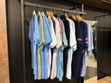 a lot of shirts hanging on a rack in a store