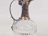 an antique silver plated glass pitcher on a white background