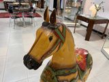 a wooden horse statue in the middle of a room