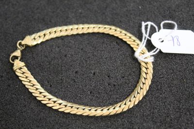 gros plan d'un bracelet en or portant une étiquette de prix